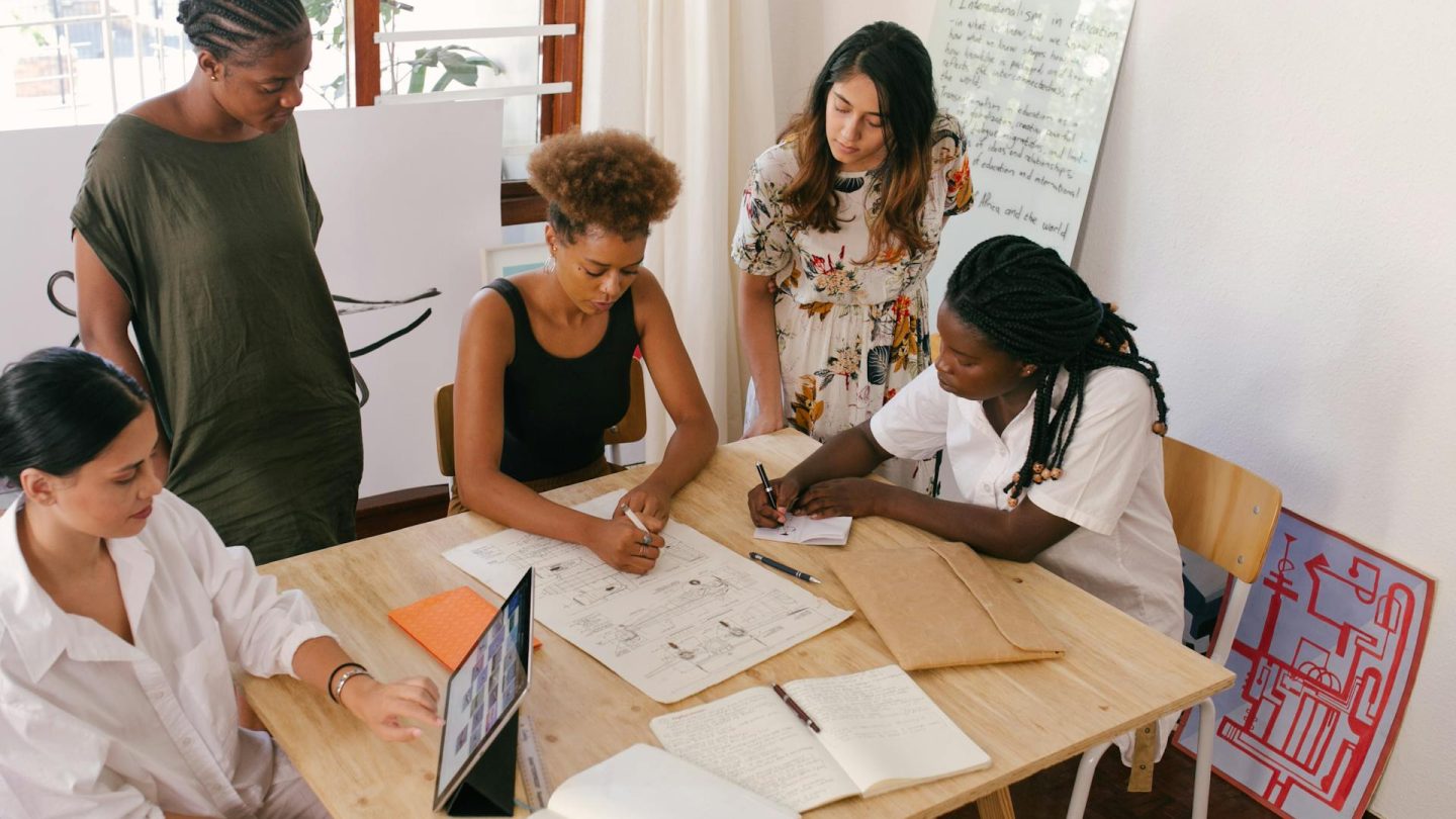 Individuals at company gathered around table in team working session