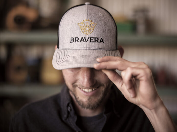 A man wears a baseball cap with the Bravera branding