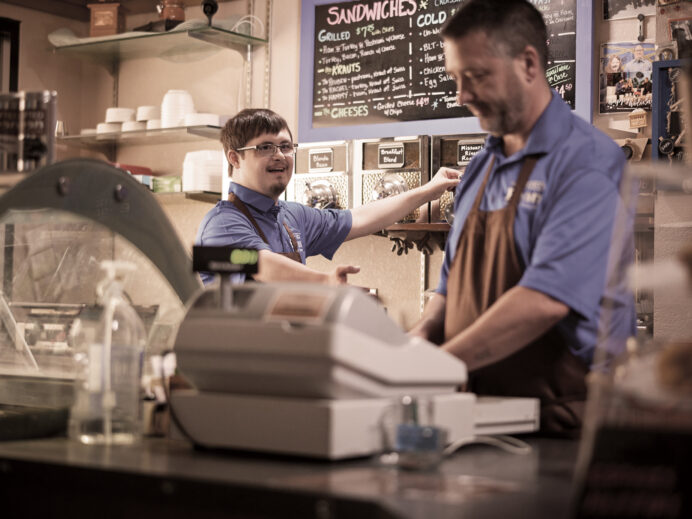 An image from the Bravera marketing collateral of two men wearing aprons working in a coffee shop